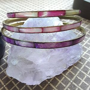 Mother of pearl shell bangle bracelets (3) with brass centers. 2 pink, 1 purple.